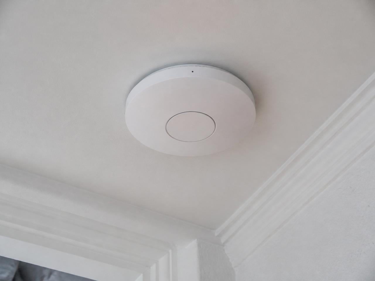Tekniker monterer WiFi access point i loft