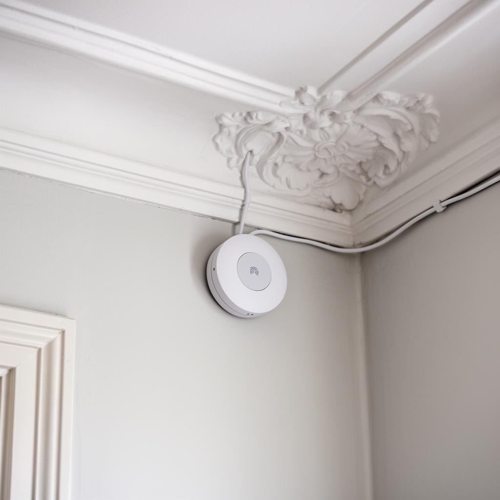 Tekniker monterer WiFi access point i loft